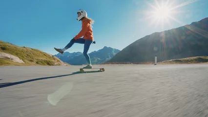 Deurstickers woman skateboarding and making tricks between the curves on a mountain pass. © oneinchpunch