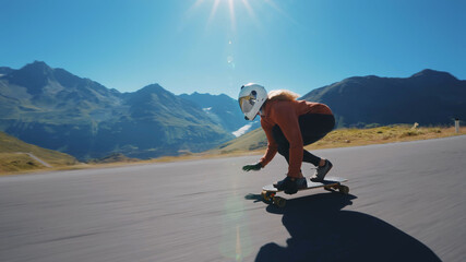 woman skateboarding and making tricks between the curves on a mountain pass.