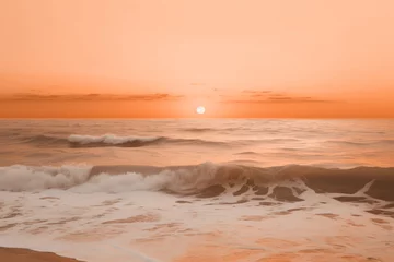 Foto op Plexiglas A serene beach at sunset with gentle waves under a soft peach fuzz color sky. Modern trendy tone hue shade © Cherstva