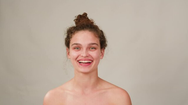 Portrait of young brunette woman looking at the camera and smiling. Wriggle and ape at the camera