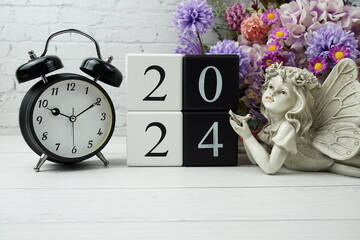 Happy New Year 2024 with wood block number on wooden table background decorations with alarm clock...