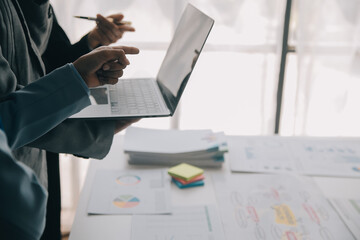 Financial analysts analyze business financial reports on a digital tablet planning investment...
