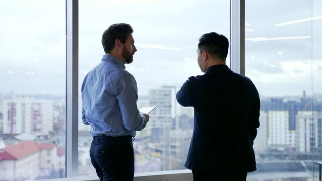 silhouette of employees talking in front of the window in modern office. Business people two partners colleagues having discussion Managers, investors or owners communicate meeting indoor