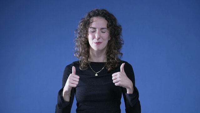 Proud woman pointing to self giving thumbs up recognizing her own success