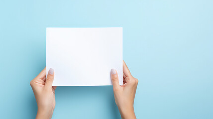 Bright and inviting portrayal of woman's hands presenting folded blank paper sheet or booklet, against pastel blue background, Focus on crispness of paper and clean, AI Generated