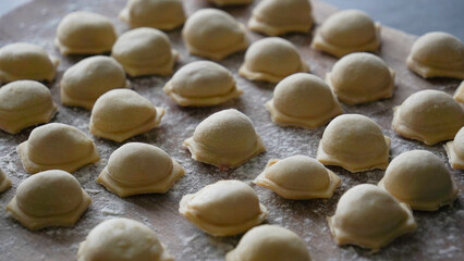 Closeup on homemade dumplings on the wooden board, horizontal  