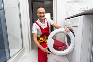 Professional mechanic repairing washing machine in domestic interior