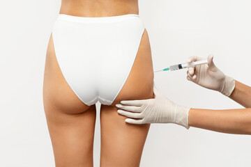 Close-up of healthcare professional in gloves administering an injection into the upper thigh