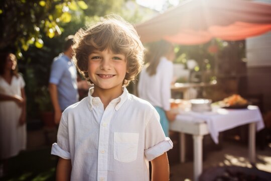 Portrait of smiling boy standing in front of his friends at barbecue party