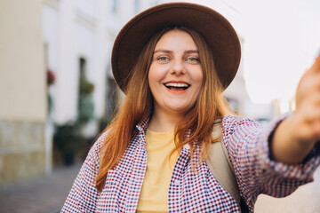 Young beautiful girl in hat say Hi. Photo relaxed charming positive woman hold camera and make...