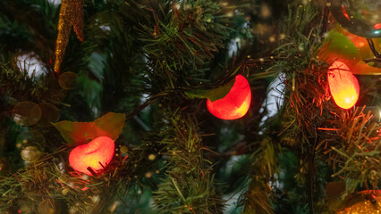Christmas tree decoration with heart-shaped red and yellow light balls on branches