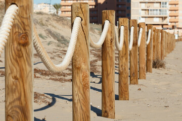 Valla limite de playa con madera y cuerda en los Arenales del Sol, España