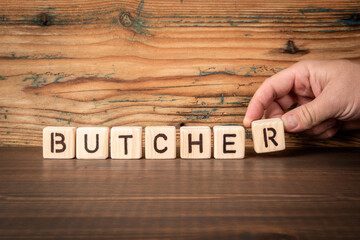 BUTCHER. Alphabet blocks on wood texture background