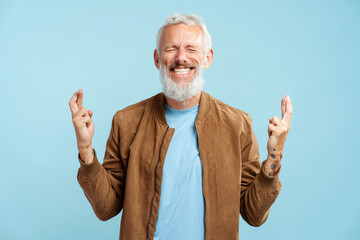 Portrait smiling gray haired bearded mature man wearing stylish casual jacket with fingers crossed