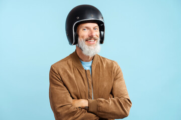Portrait of bearded man mature biker wearing black protective helmet, brown jacket with arms crossed