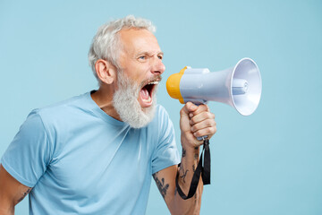 Portrait of mature man with beard holding megaphone shouting, saying something looking away
