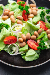 white bean salad green lettuce, tomato, onion healthy eating appetizer meal food snack on the table copy space food background rustic top view