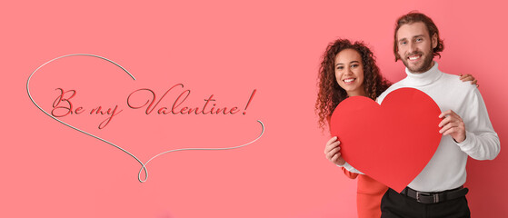 Happy young couple with red paper heart on color background. Valentine's Day celebration