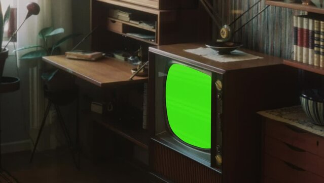 Retro TV Green Screen Inside House Vintage Television Tilt Down. Old retro television with green screen, for replacement, inside a vintage house. Tilt up