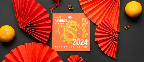 Greeting card with paper fans and tangerines on black background. Chinese New Year celebration