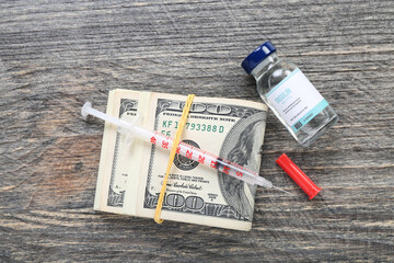 Fototapeta na wymiar Insulin with syringe and money on dark wooden background. Expensive medicine concept
