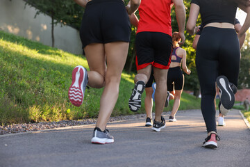 Group of people running outdoors, closeup view