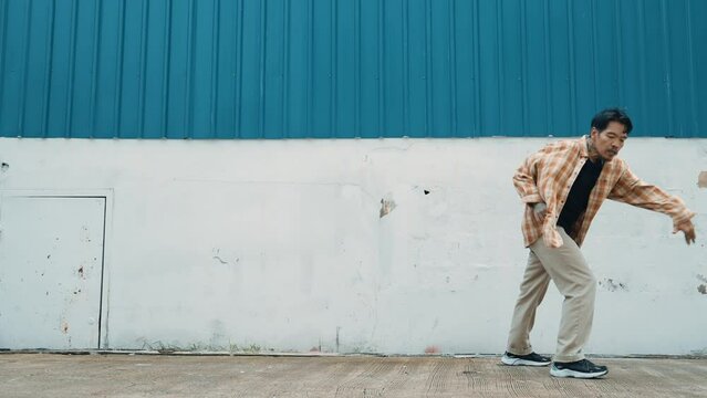 Hispanic funny choreographer dancing in hip hop style. Young happy break dancer perform b-boy dance. Motion shot of funny man practicing street dancing. Outdoor sport 2024. Modern dance. hiphop.