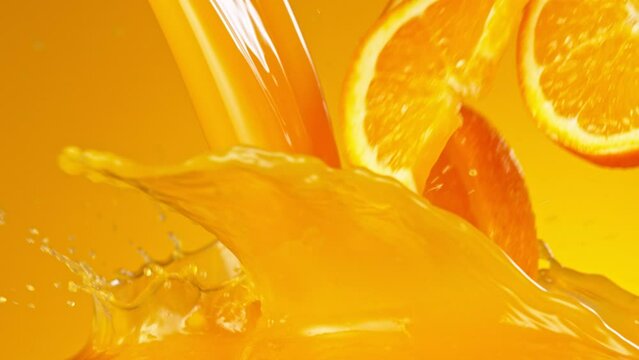 Orange slices splashing into juice, macro shot. Macro background. Filmed on a high-speed cinema camera at 1000 fps.