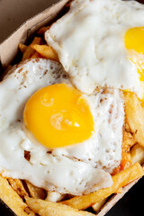 papas fritas con huevos fritos en caja de delivery