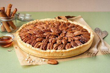 Tasty pecan pie on green background