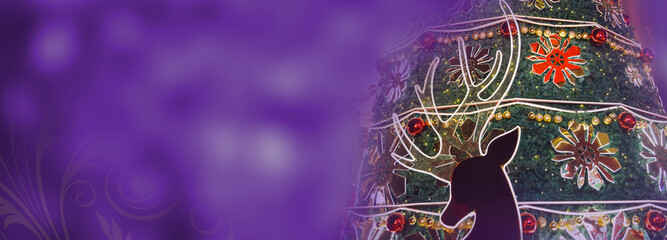 Closeup of a Christmas Tree on purple bokeh background with floral swirl. Christmas Reindeer. Copy...