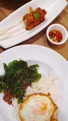 Thai street food rice topped with egg and stir-fried beef and basil, Thai meat ball with chilli sauce famous street food in Thailand, fast food.