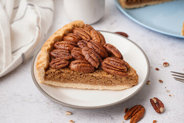 Plate with piece of tasty pecan pie on light background