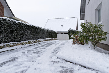 Snow-covered access road to a house - 692186307