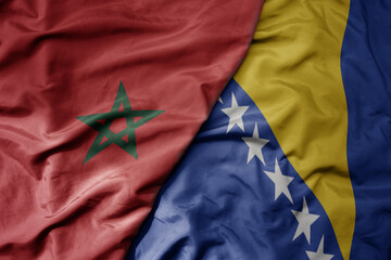 big waving national colorful flag of bosnia and herzegovina and national flag of morocco .