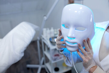 Woman getting cosmetic procedure with LED facial mask. , photon therapy