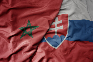 big waving national colorful flag of slovakia and national flag of morocco .