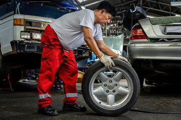 Mechanician changing car wheel in auto repair shop. changing wheels/tires. Concept of car care...