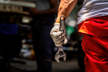 car mechanic in an auto repair shop is checking the engine and Other auto part