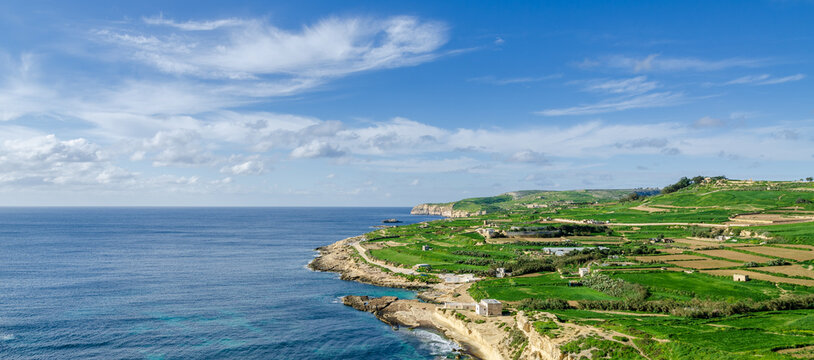 Mgarr, Malta - Panorama of Xatt l-Aħmar bay and cliffs in Malta at with beautiful colorful sky and golden rocks taken from near fort chambray