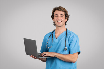 Health care and telemedicine. Smiling male medical worker wearing blue uniform coat and stethoscope...