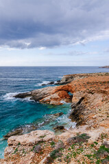 The Xaqqa Cliffs: Breathtaking view of the steep and rocky coastline and the ocean with crystal clear turquoise blue water. Climbing experience on the island of Malta. A paradise in europe.
