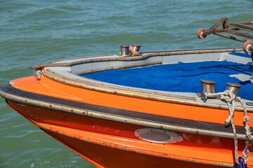 Oranges Boot mit blauer Plane im grünen Wasser