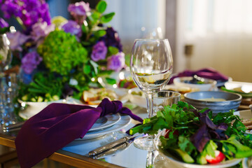 Beautiful festive table setting with flowers and purple napkins.  - obrazy, fototapety, plakaty
