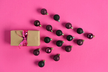 Gift box and Christmas balls on pink background
