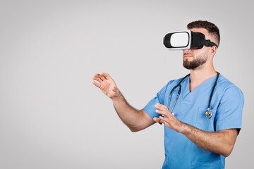 Male nurse in blue scrubs using a VR headset, copy space