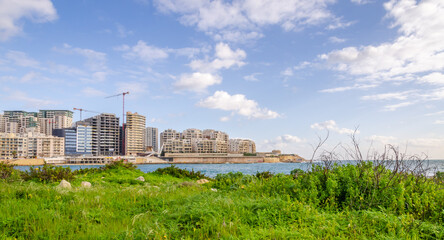 Fototapeta na wymiar Sliema, major residential and commercial area and a centre for shopping, dining, and cafe life in Malta. Skyline in the Strand and Tigne Point during day as seen from Manoel Island