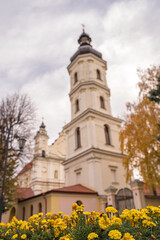 Fototapeta na wymiar Church of the Assumption of the Blessed Virgin Mary in Pinsk on a quiet warm autumn morning against the background of blooming autumn