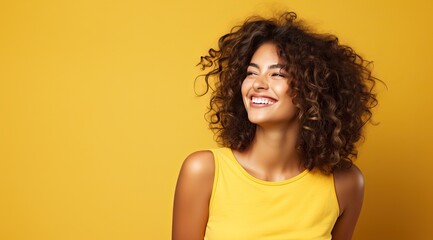 Beautiful young woman smiling over yellow background.