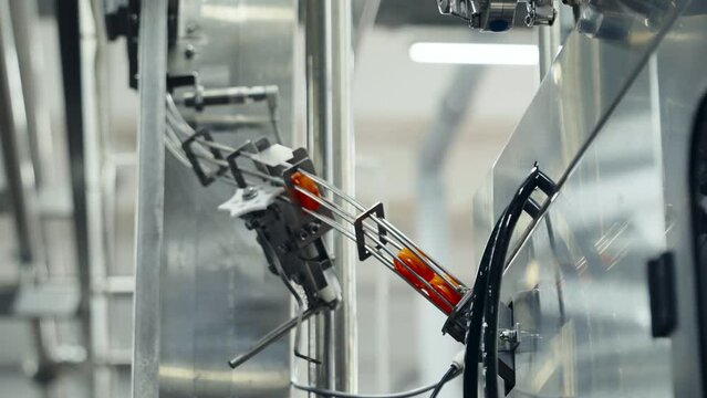 Huge amounts of red bottle caps progressing through the industrial machine. Bottle caps are being processed by the industrial equipment. Bottle caps are stuck on the entrance of the industrial machine